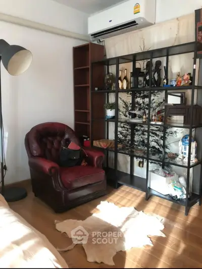 Cozy living room with leather armchair, decorative shelving, and natural light