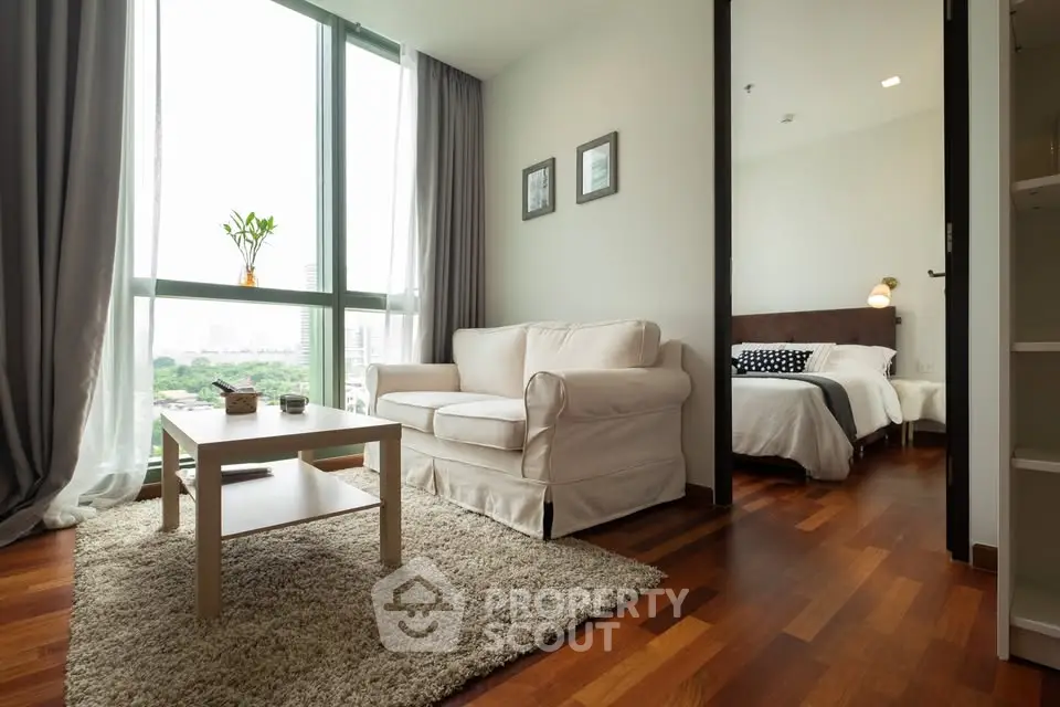 Modern living room with cozy seating and large windows offering a stunning city view.