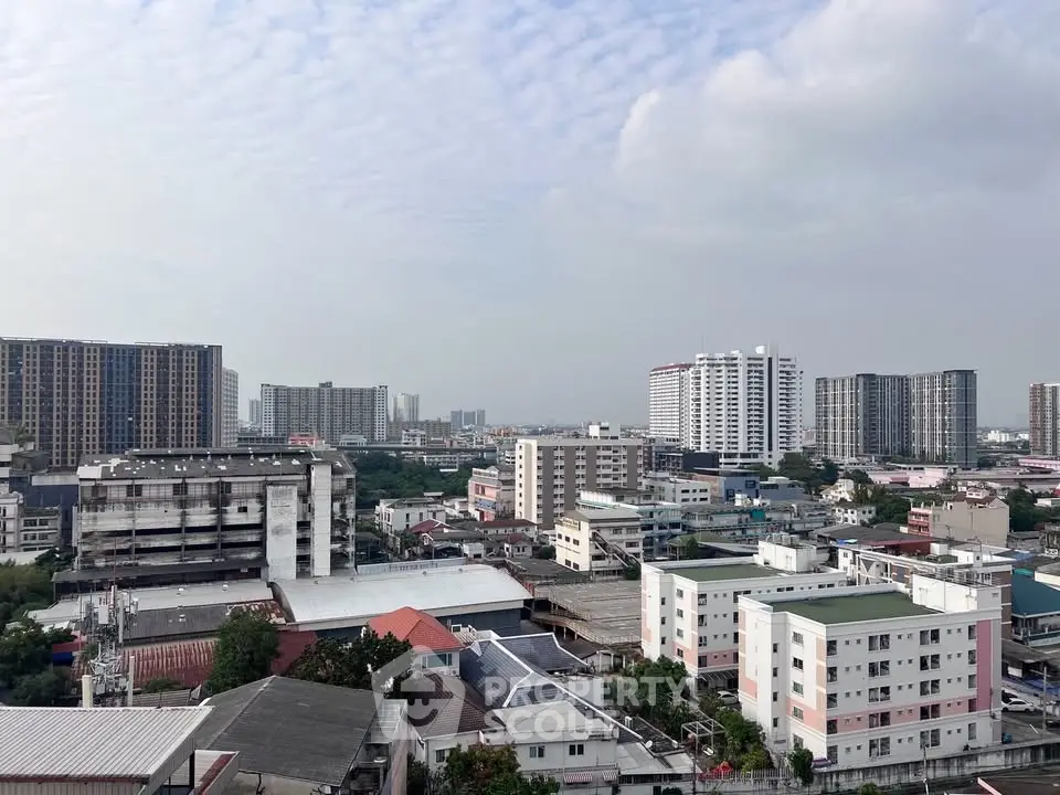 Panoramic cityscape view showcasing diverse urban architecture and skyline under a cloudy sky.