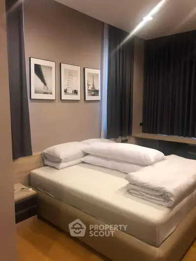 Cozy bedroom with modern decor and framed art, perfect for relaxation.