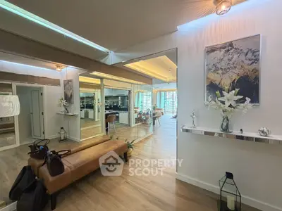 Elegant living room with modern decor and large mirrors enhancing spaciousness