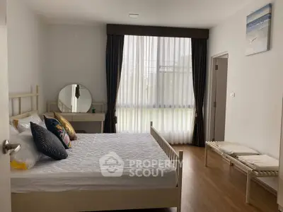 Spacious bedroom with elegant decor and large window for natural light
