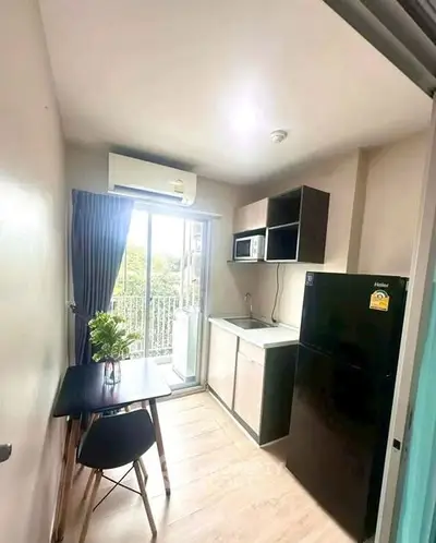 Compact kitchen with balcony view, featuring modern appliances and sleek design.