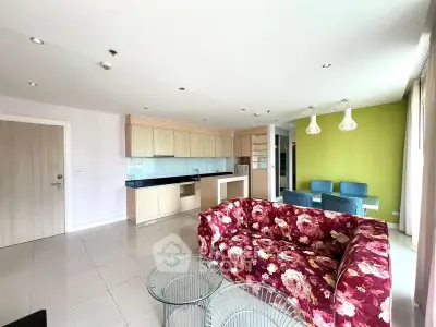 Spacious modern living room with floral sofa and open kitchen layout