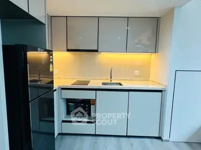 Modern kitchen with sleek cabinetry and built-in appliances in a compact layout.