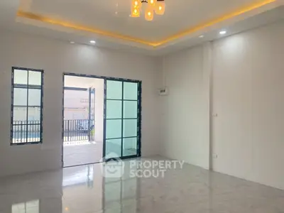 Spacious modern living room with large windows and elegant lighting.