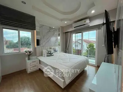 Modern bedroom with large windows and stylish decor, featuring a cozy bed and scenic view.