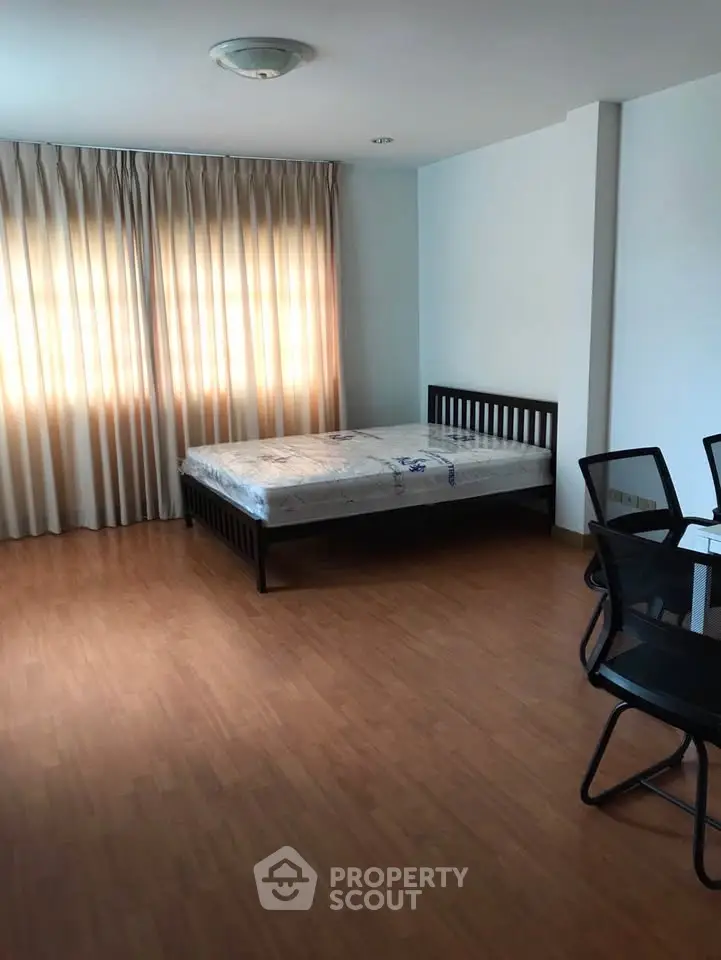 Spacious bedroom with natural light and modern furnishings