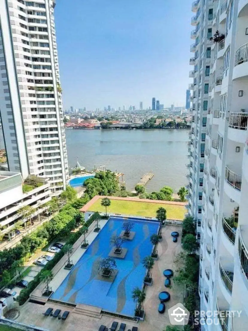 Luxurious high-rise condo with a stunning river view, featuring a large swimming pool and lush garden, nestled in a vibrant cityscape.