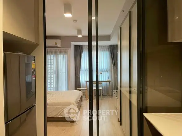 Modern studio apartment with open layout, featuring a cozy bedroom and sleek kitchen area.