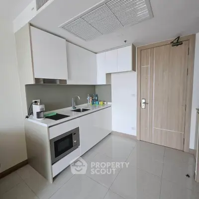Modern kitchen with sleek cabinetry and built-in microwave in a contemporary apartment.