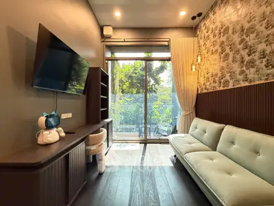 Stylish living room with modern decor and large window overlooking lush greenery.
