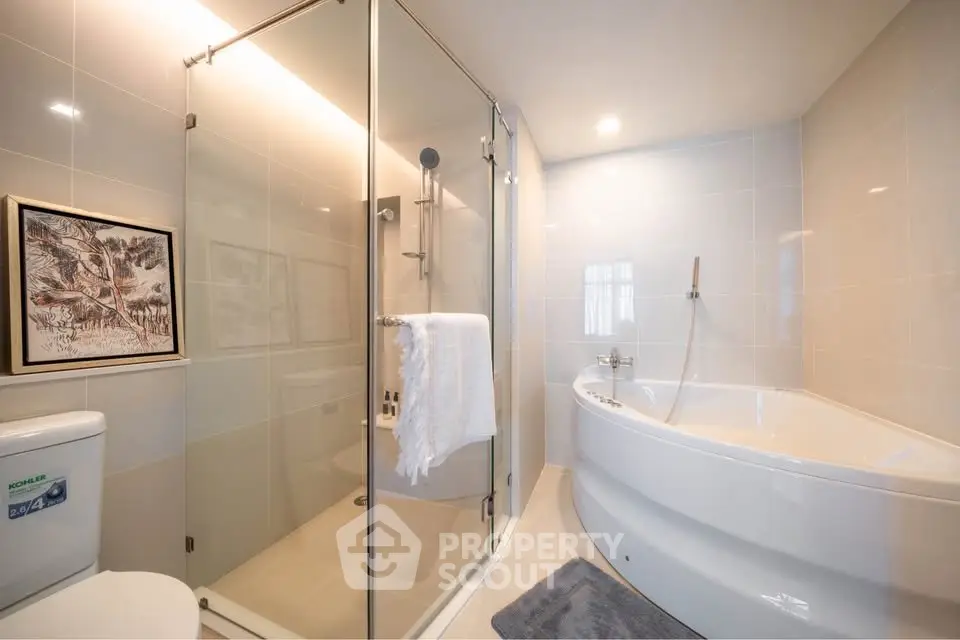 Luxurious bathroom with corner bathtub and glass shower enclosure