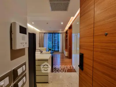 Modern apartment entrance leading to a spacious living room with city view.