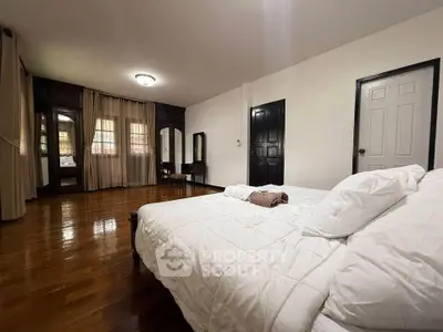 Spacious bedroom with elegant wooden flooring and classic furnishings