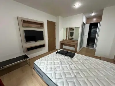 Modern bedroom with wall-mounted TV and stylish wooden furniture, perfect for comfortable living.