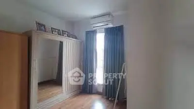 Spacious bedroom with large mirror and natural light