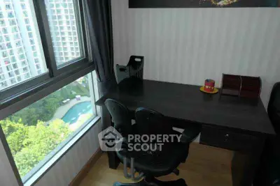 Cozy study room with desk and chairs overlooking a scenic view from a high-rise window.