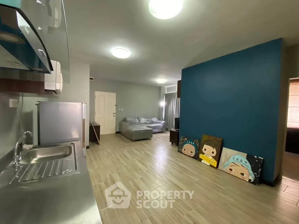 Spacious modern living room with open kitchen and unique wall art