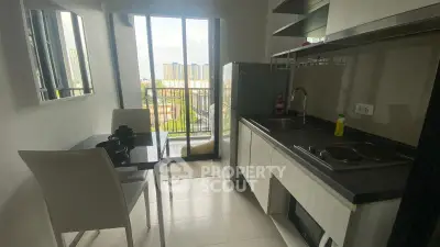 Modern kitchen with balcony view, sleek design, and dining area in a compact space.