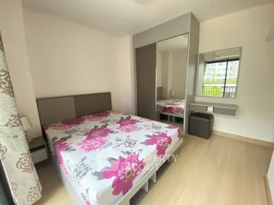Modern bedroom with floral bedding and mirrored wardrobe in bright apartment