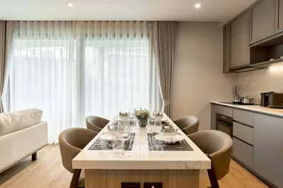 Modern dining area with elegant table setting and natural light from large windows.