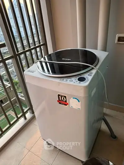 Modern washing machine on a high-rise balcony with city view