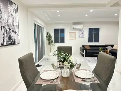 Elegant dining and living area with modern decor and ample natural light