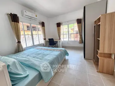 Spacious bedroom with natural light and modern furnishings