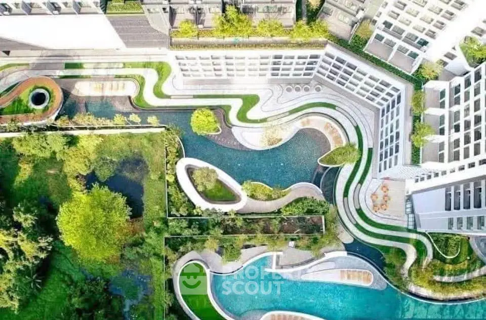 Stunning aerial view of modern apartment complex with lush gardens and winding pathways.
