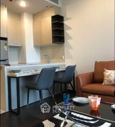 Modern open-layout kitchen and living area with stylish furniture and dining space.