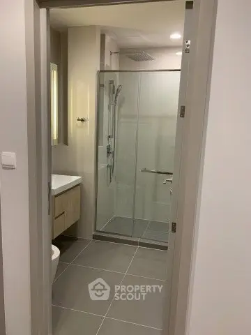 Modern bathroom with glass shower enclosure and sleek fixtures.