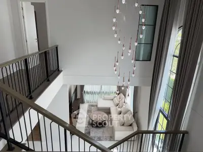 Luxurious modern living room with high ceilings and elegant chandelier
