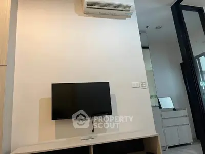 Modern living room with wall-mounted TV and air conditioning unit, showcasing sleek interior design.