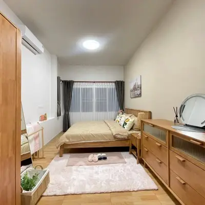Cozy bedroom with wooden furniture and soft lighting, perfect for relaxation.