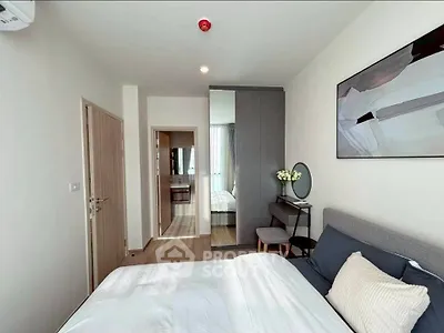 Modern bedroom with stylish decor and ample natural light, featuring a cozy bed and elegant furnishings.