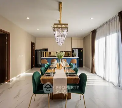 Luxurious dining area with elegant chandelier and modern kitchen in open layout