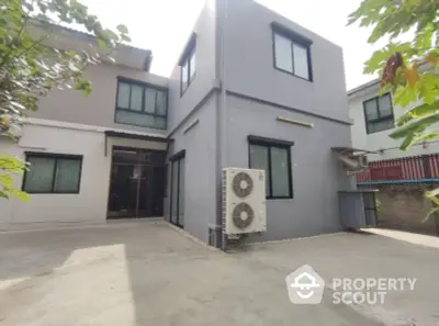 Modern two-story house exterior with air conditioning unit and spacious driveway