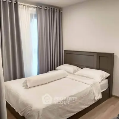 Cozy bedroom with elegant curtains and a comfortable bed in a modern apartment.