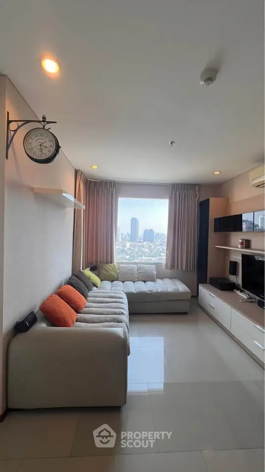 Modern living room with city view, featuring a cozy sectional sofa and entertainment center.