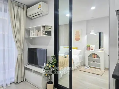 Modern living room with sliding glass door to cozy bedroom, featuring stylish decor and natural light.