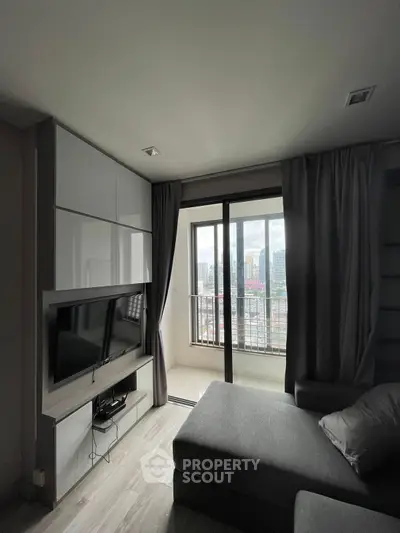 Modern living room with sleek TV setup and city view balcony