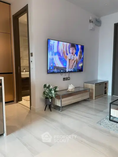 Modern living room with sleek TV setup and stylish furniture in a contemporary apartment.