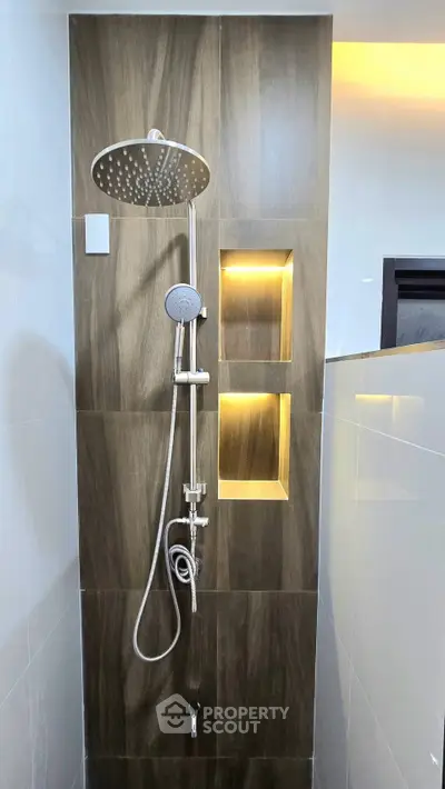 Modern bathroom shower with elegant wood paneling and built-in lighting