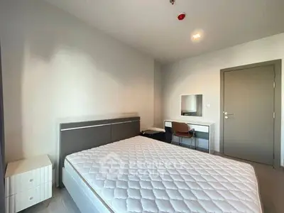 Modern bedroom with minimalist design and ample natural light, featuring a comfortable bed and stylish furniture.