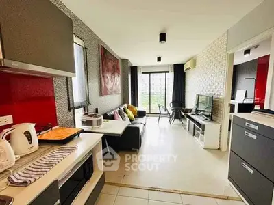 Modern open-layout living room with kitchen, featuring stylish decor and natural light.