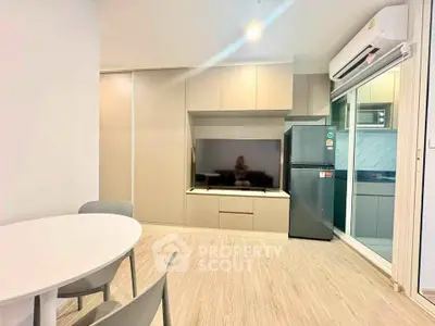 Modern living room with sleek furniture and integrated kitchen appliances in a stylish apartment.