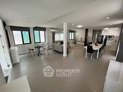 Spacious open-plan living and dining area with modern kitchen in a bright, airy home.