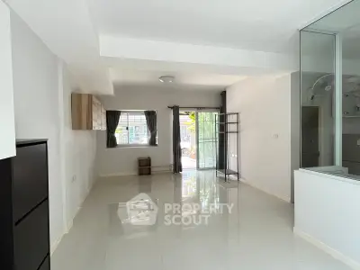 Spacious modern living room with large windows and glossy tiled floors, perfect for natural light and open living.
