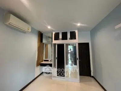 Spacious bedroom with built-in wardrobe and air conditioning in modern apartment.
